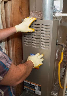 Performing repair on a furnace, starting with taking off the cover.